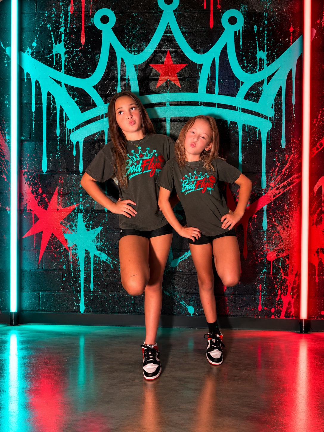 BadFlyer Crowned Different tee modeled in charcoal with teal crown graphic